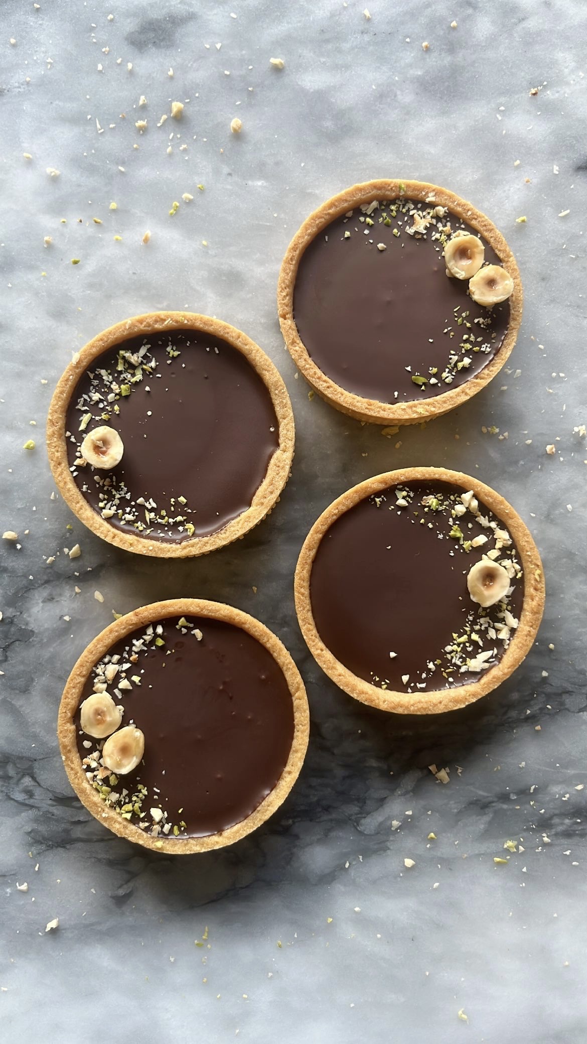 A chocolate tart topped with hazelnut arranged decoratively