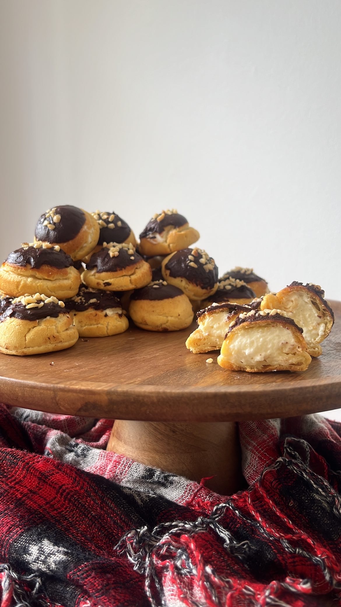 Choux pastry with chocolate and nuts on top and cream inside