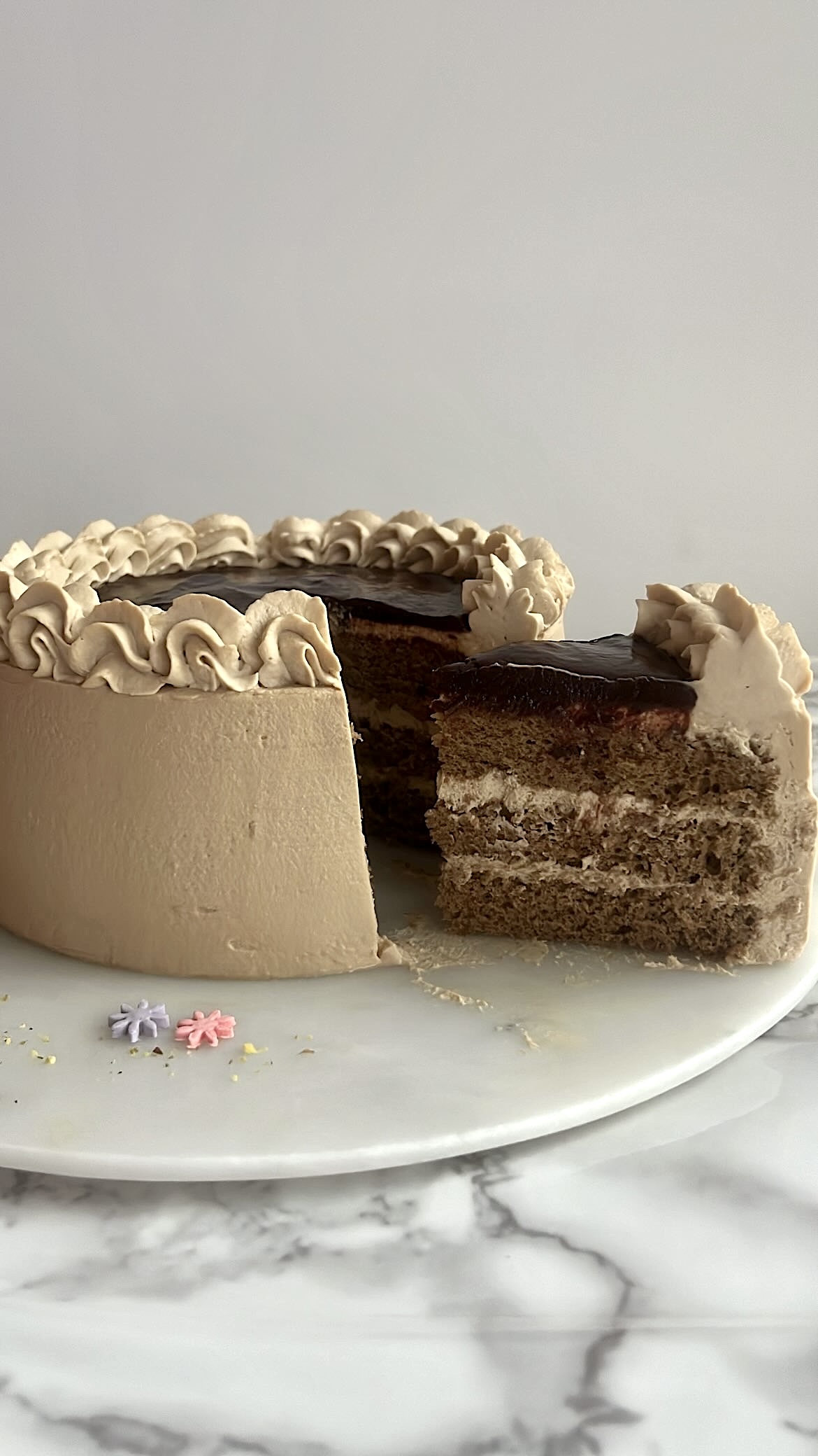 Coffee genoise cake with visible inner layers, showing its fluffy texture and cream filling.