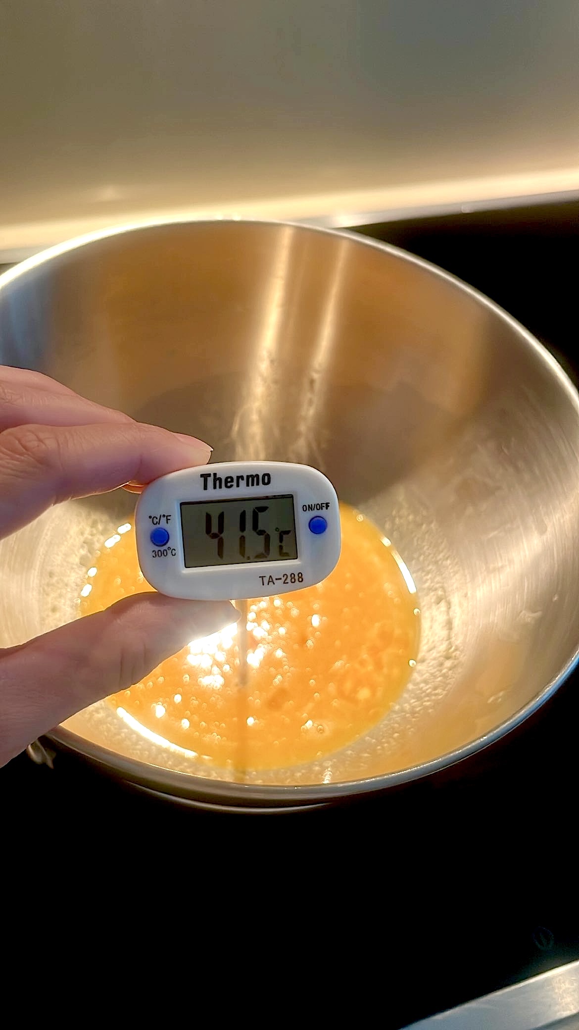 Egg mixture being heated to 40°C over simmering water