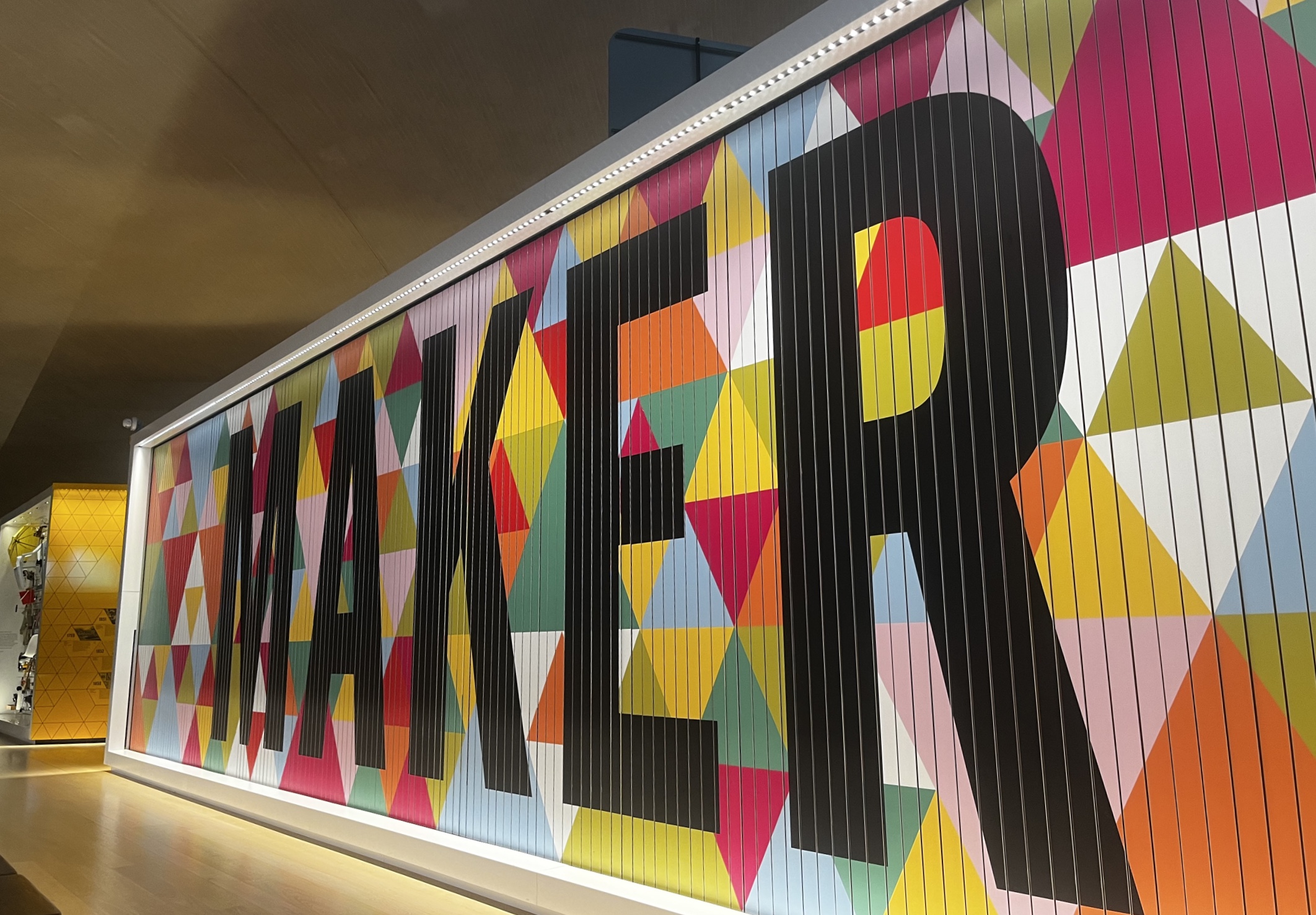 A vibrant and colorful display featuring the word 'Maker' at the Design Museum, emphasizing creativity and innovation in design.