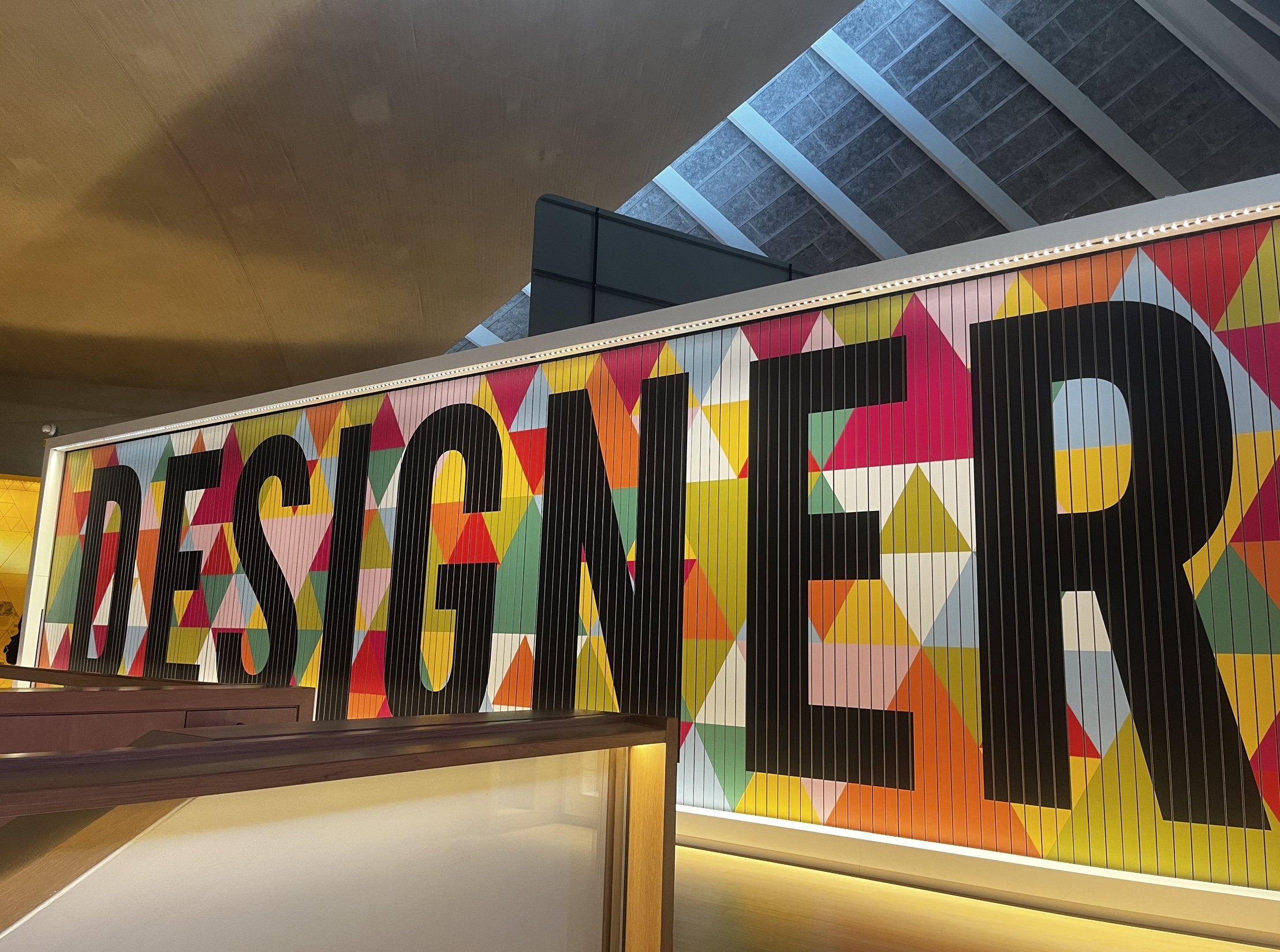 A vibrant and colorful display featuring the word 'Designer' at the Design Museum, emphasizing creativity and innovation in design.