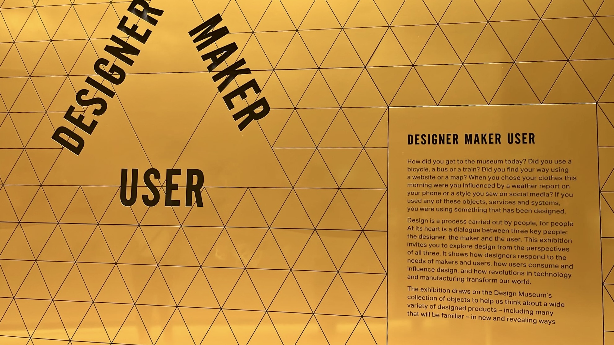 A wall at the Design Museum visually expressing the relationship between designer, maker, and user, with diagrams and objects highlighting the collaborative process of product creation.