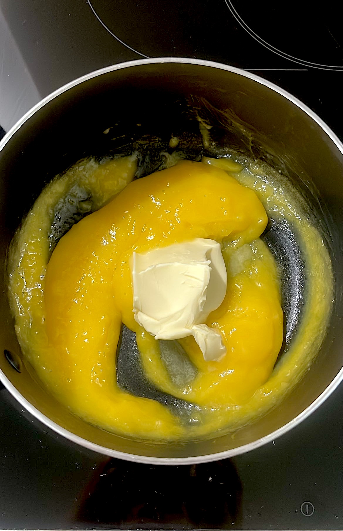 Butter being added to the thickened lemon filling