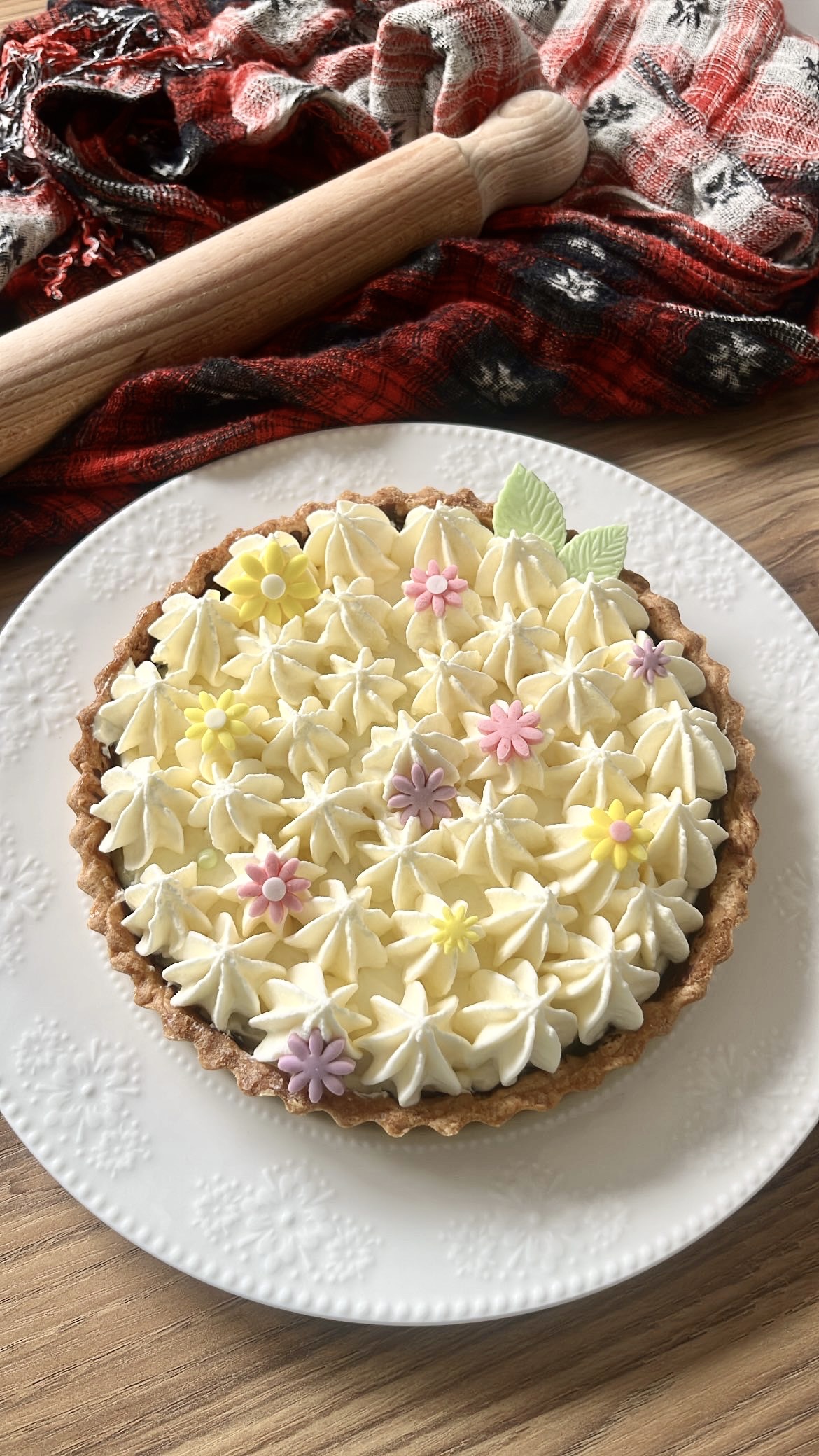 Four lemon tarts decorated with wave-shaped cream on top