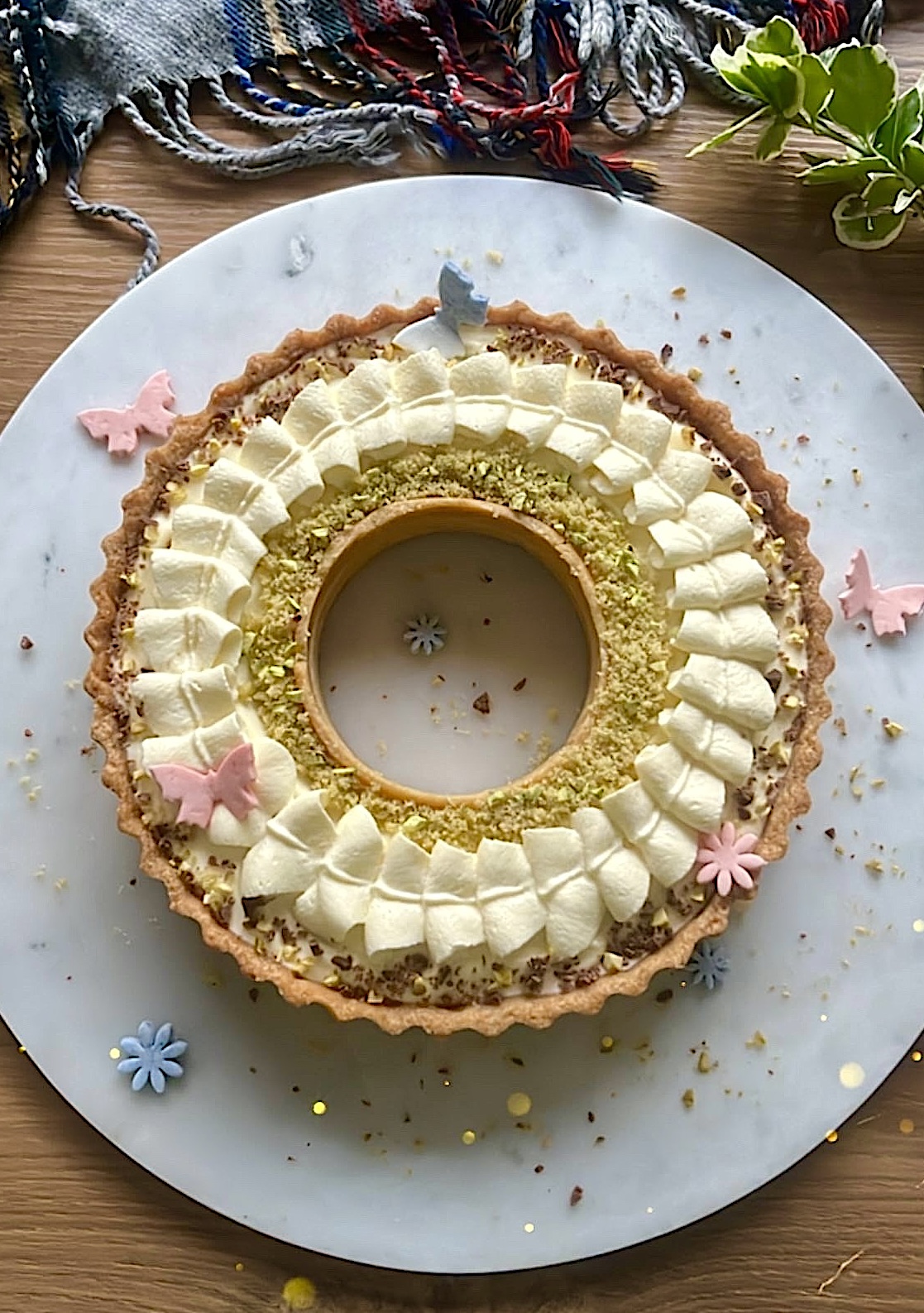 Tart ring topped with ribbon-shaped cream, decorated with butterfly-shaped sugar toppers.