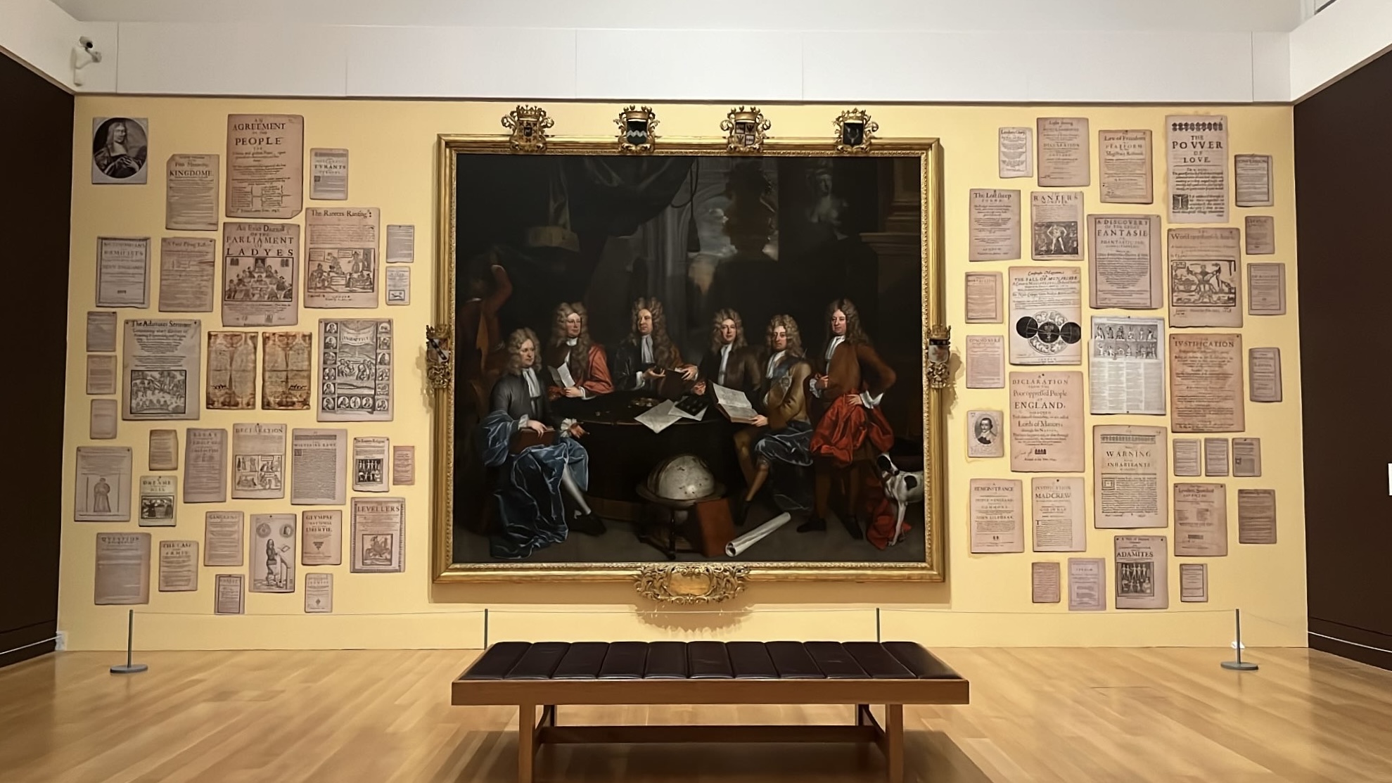 Wall display featuring an array of ancient artifacts in Tate Britain, highlighting the historical significance and craftsmanship of each piece.