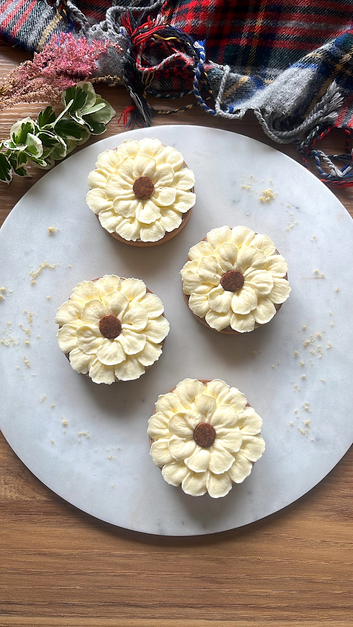 Four tarts with flower-shaped cream piping on top